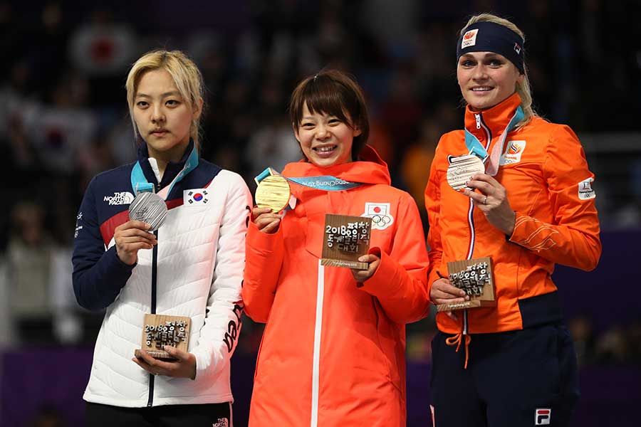 高木菜那（中央）らとともに、真剣な表情で銀メダルを掲げるキム・ボルム（右）。【写真：Getty Images】