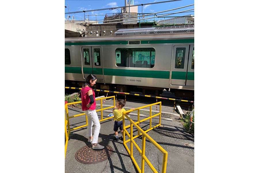 踏切で電車に喜ぶ長男と中野さん（写真は一部加工）【写真：本人提供】
