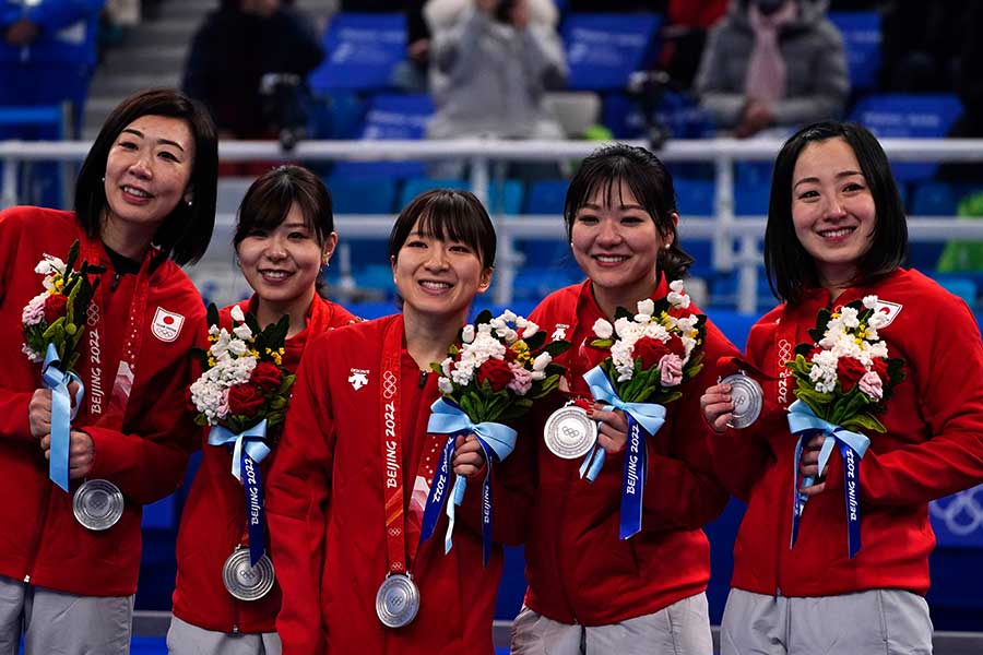 北京五輪カーリング女子で銀メダルを獲得した日本代表の吉田夕梨花（左から2人目）と鈴木夕湖（中央）【写真：AP】