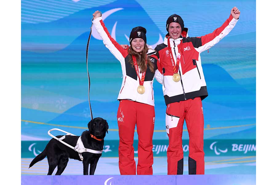 クロスカントリースキー女子スプリントフリー視覚障害で金メダルを獲得したカリーナ・エドリンガー（左）と盲導犬のライリー【写真：Getty Images】