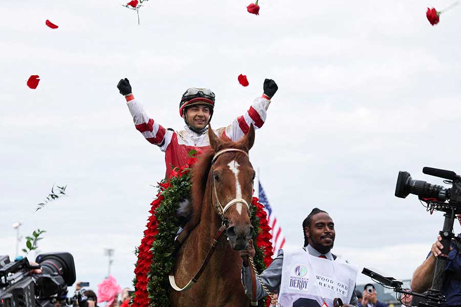 バラを投げて祝福するソニー・リオン騎手とリッチストライク【写真：ロイター】