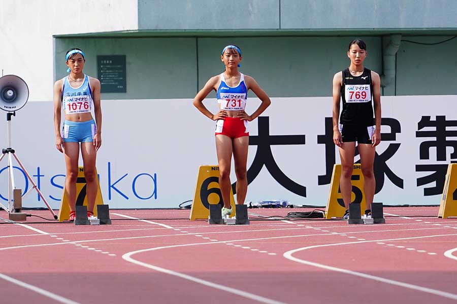 女子100メートル決勝、スタートラインに立った小針陽葉（中央）【写真：荒川裕史】
