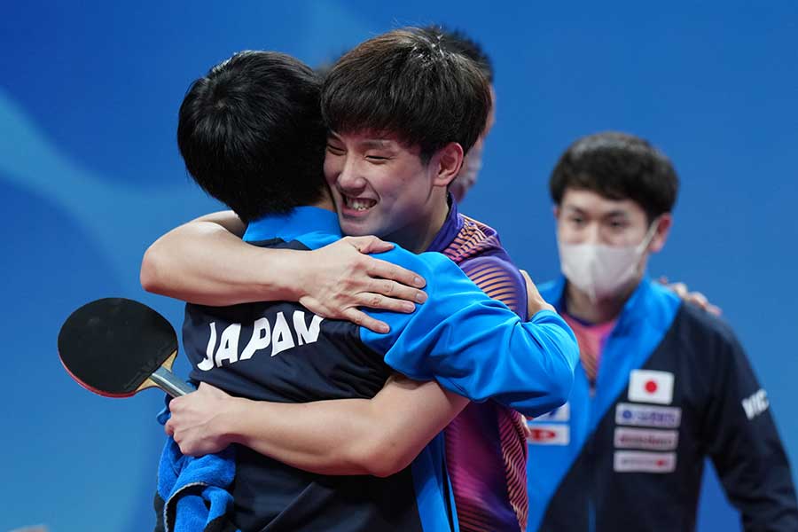 第4試合に勝利し、チームメイトと歓喜の抱擁を交わす張本智和【写真：Getty Images】