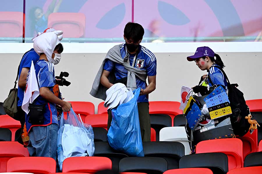 試合後の客席でゴミを拾う日本人サポーター【写真：ロイター】