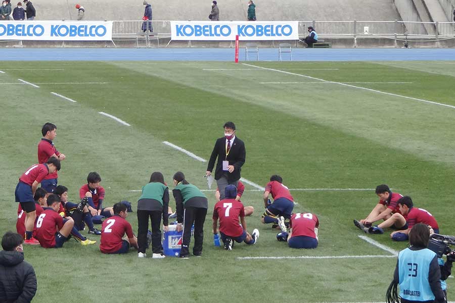 ハーフタイムに監督から指示を受ける倉吉東の選手たち。わずか15人という少なさがグラウンドでも際立った【写真：吉田宏】