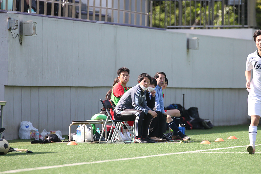 合同チームを率いる佐藤義幸監督（手前）。ベンチ入りメンバーも2人と少ない【写真：平野貴也】