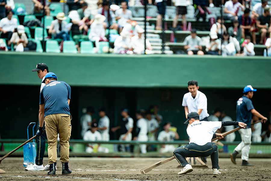 球場係員（左）と比べても際立つ横浜隼人の補助員の腰の低さ【写真：中戸川知世】