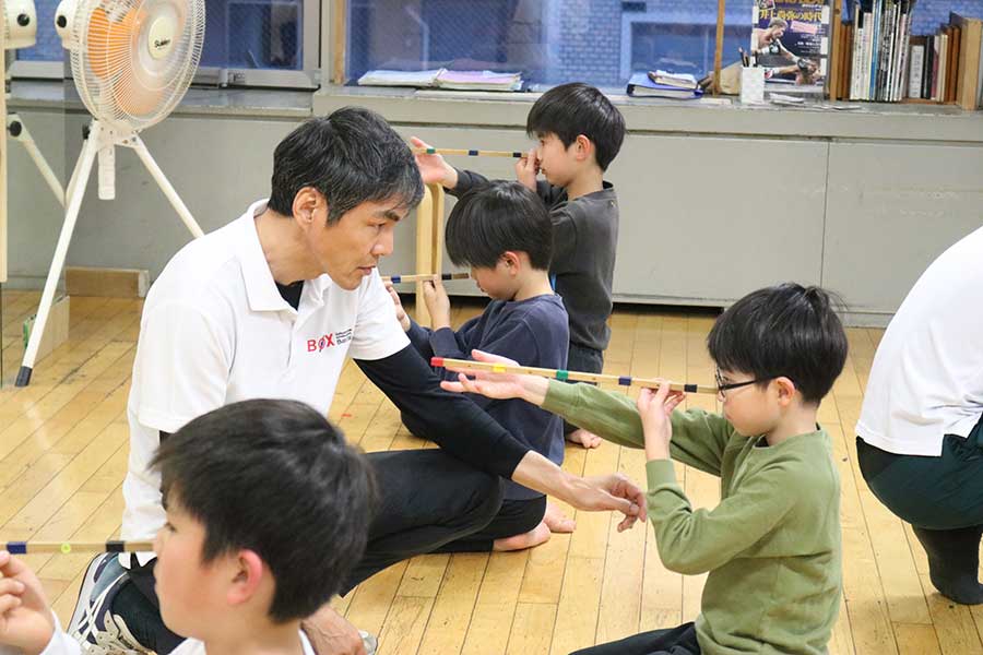 自身の運動塾で子どもを指導する飯田覚士氏（中央左）【写真：山野邊佳穂】