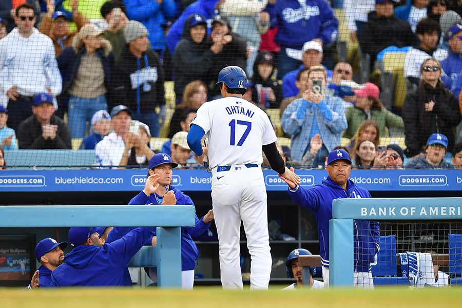 ベンチで同僚らとハイタッチするドジャースの大谷翔平【写真：ロイター】