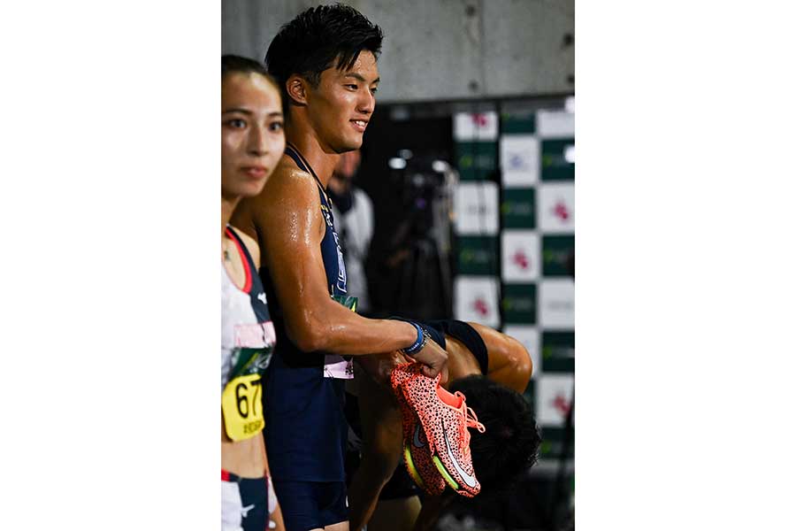 膝に手をついて気落ちする2年生アンカー大石凌功の顔をシューズでカメラからそっと遮った柳田大輝【写真：中戸川知世】