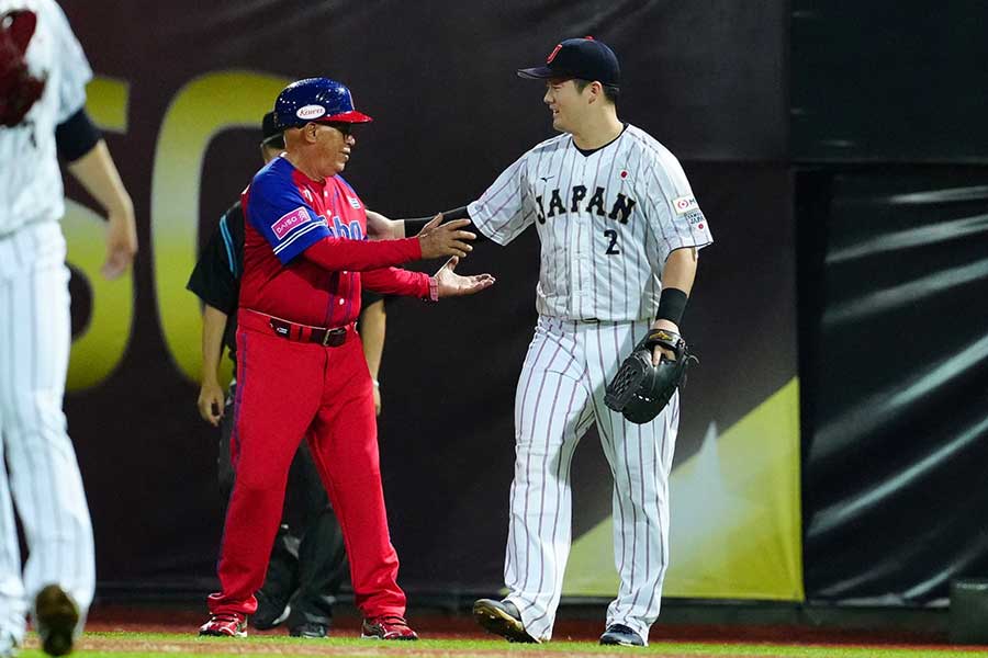 侍ジャパンの牧秀悟（右）とキューバのアルマンド・フェレル一塁ランナーコーチ【写真：小林靖】