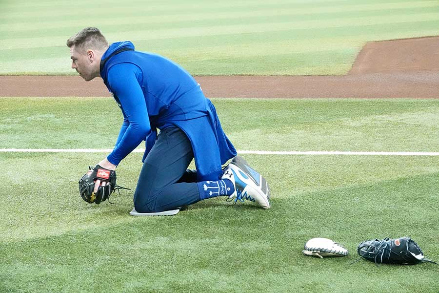 膝をついてゴロ捕球するフリーマン、「ボールに向かってプッシュするように出す」がコツだ【写真：鉾久真大】