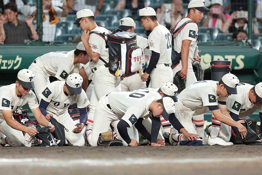 沖縄尚学に敗れ、涙を流しながら甲子園の土を拾う東洋大姫路ナイン【写真：スポーツ報知/アフロ】