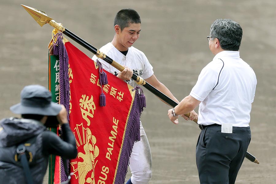 優勝旗を受け取る沖縄尚学の真喜志拓斗主将【写真：スポーツ報知/アフロ】
