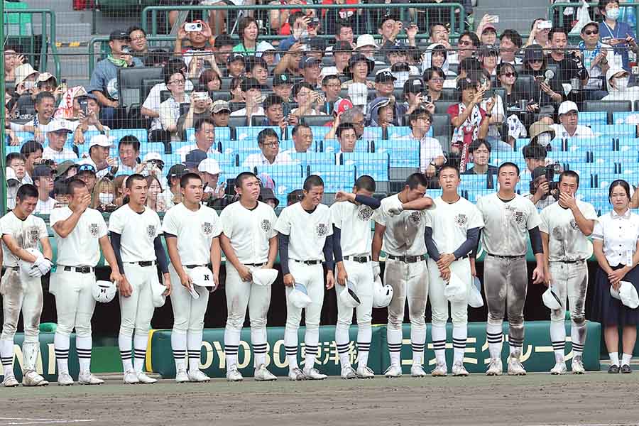 決勝で沖縄尚学に敗れ、ベンチ前に整列する日大三の選手たち【スポーツ報知/アフロ】