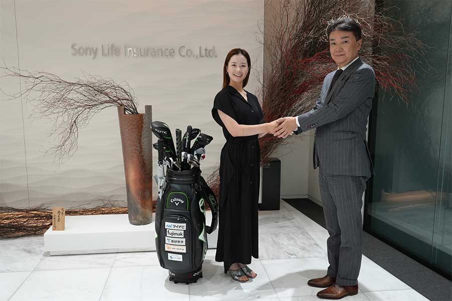 契約成立でソニー生命の浅沼裕治専務（右）と握手を交わす青木