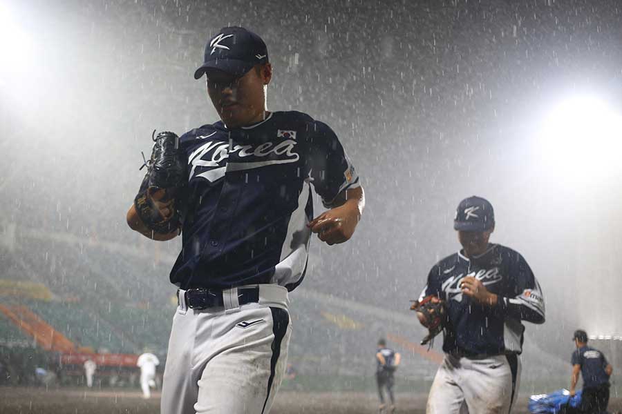 7日の試合で雨のためベンチに駆け込む韓国代表【写真：羽鳥慶太】