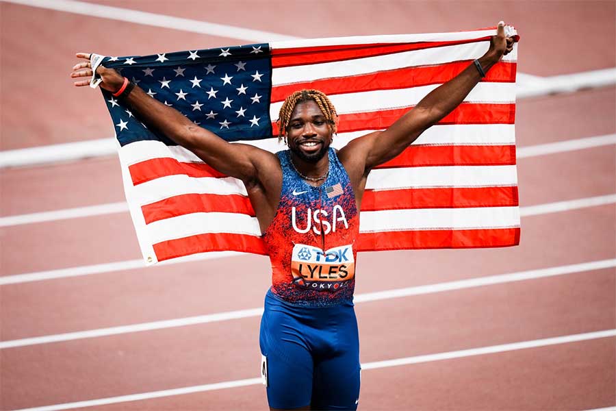 男子100メートルで銅メダルを獲得し、国旗を掲げるノア・ライルズ【写真：中戸川知世】