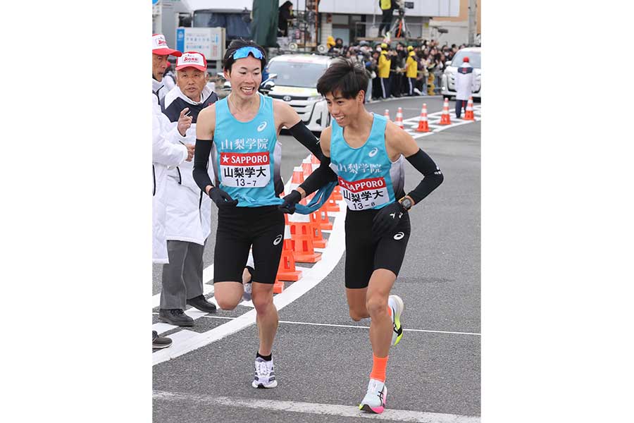 1月の箱根駅伝、平塚中継所でタスキをつなぐ山梨学院大7区の大杉亮太朗（左）と山梨学院大8区の阿部紘也【写真：産経新聞】