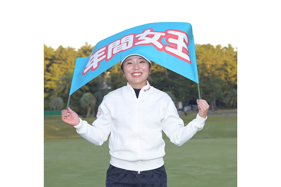 「年間女王」と書かれたゲートフラッグを手に笑顔を見せる佐久間朱莉【写真:スポーツ報知/アフロ】