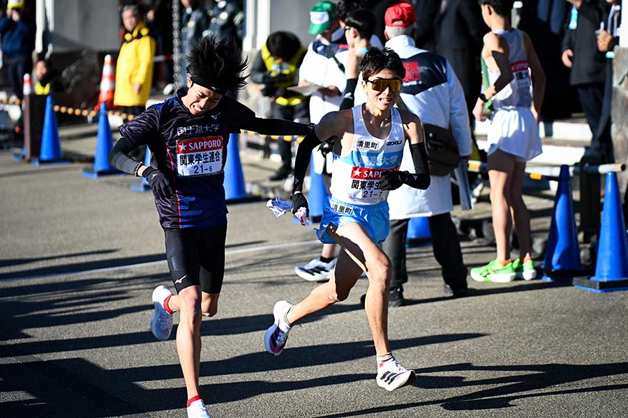 笑顔でタスキを受け取った東大・秋吉拓真（右）【写真：中戸川知世】