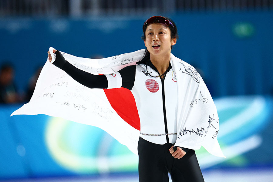 女子1000メートルで銅メダルを獲得し、国旗を背にスタンドの声援に応える高木美帆【写真：ロイター】