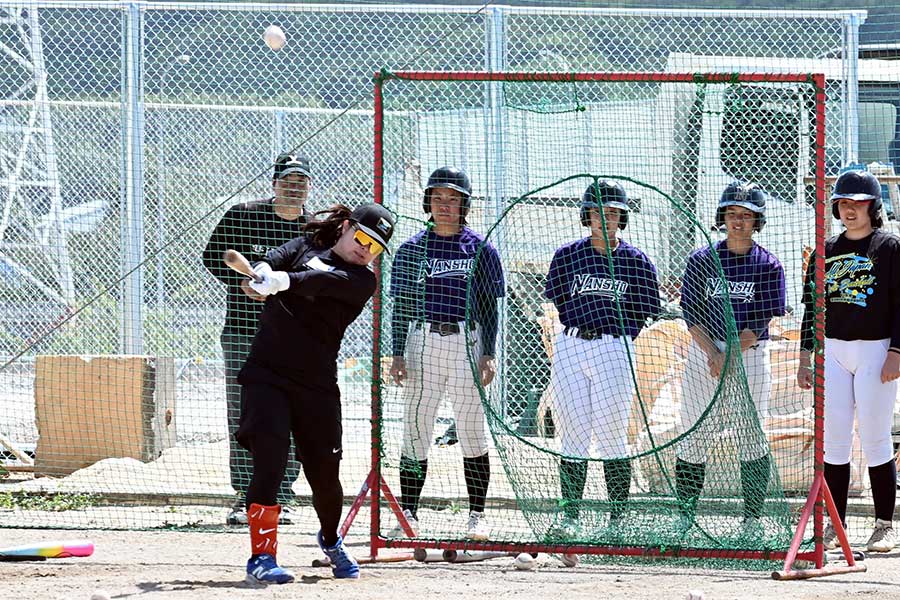 沖縄県立南部商業高校の選手たちの前で豪快なバッティングを見せる島野【写真：長嶺真輝】