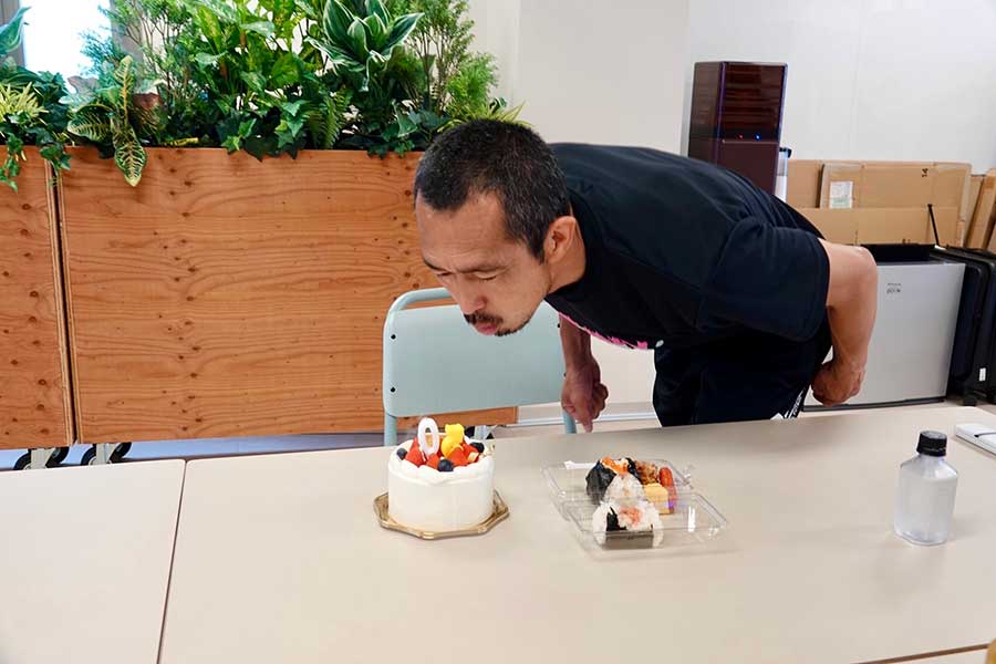 サプライズで用意された誕生日ケーキ、「50」のろうそくを吹くドラゴン【写真：須河千晶】