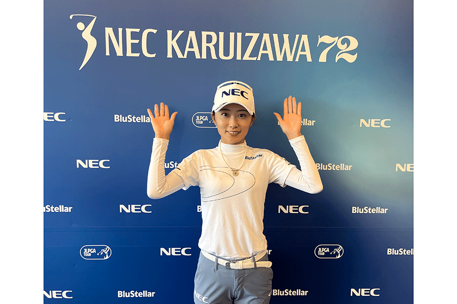 NEC軽井沢72ゴルフの大会ロゴを背に笑顔の安田祐香【写真：柳田道斉】
