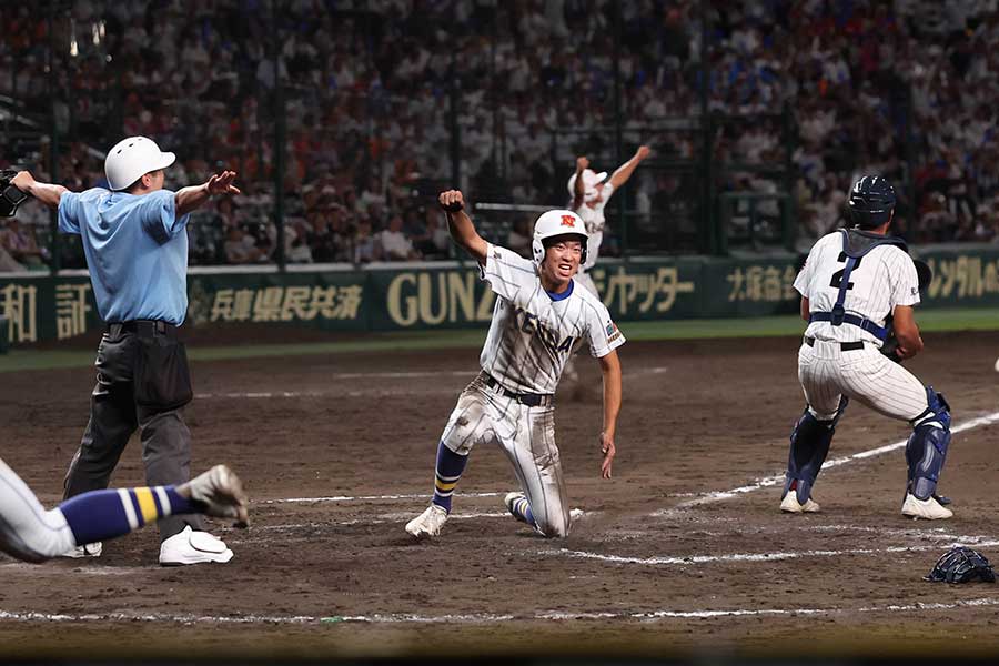 本塁生還しガッツポーズを決めた藤村勇也（中央）【写真：スポーツ報知/アフロ】